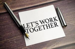 let's work together text concept write on notebook on a wooden background photo