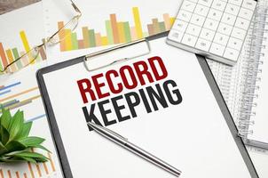 Word text RECORD KEEPING on white paper photo