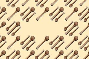 Wooden spoons, top view of wooden spoons isolated on yellow background. Kitchenware pattern with copy space. photo