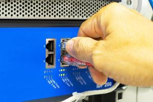 Hand of a man holding The network cables to connect the port of a switch to connect internet network, concept Communication technology photo