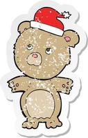 retro distressed sticker of a cartoon bear in christmas hat vector