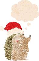 cartoon hedgehog wearing christmas hat and thought bubble in retro textured style vector