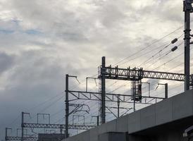 The power electric wire system is rowing along the elevated railway bridge. photo