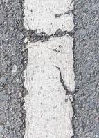 Old white stripe on the asphalt road. photo