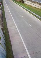 The empty concrete road to enter the expressway system with the metal fence. photo