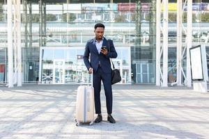 successful young confident African American businessman moving with cellphone photo