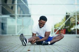 a tired man after a run massages his leg, has severe pain in the knees and muscles photo