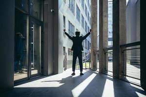 Successful african american businessman with arms up celebrating victory. photo