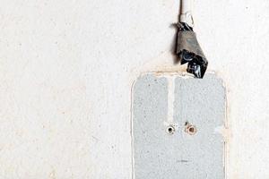 Unsafe electrical wire on the wall. Home renovation concept. photo