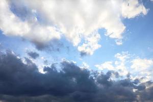 Afternoon sky, weather front, epic confrontation between light and dark clouds. Blue and white sky background with place for text. photo