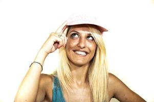 blonde girl in pink hat looks up hands on visor photo