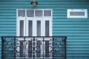 Samut Sakhon, Thailand, 2020 - White wooden door and wall lamp on balcony of the old vintage house photo