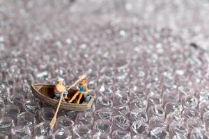 pareja en miniatura con barco navegando en burbuja rosa foto