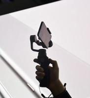 A silhouette of a mans hand holding a mobile phone on a gimbal photo