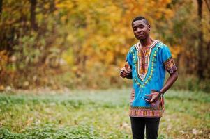 African man in africa traditional shirt on autumn park. photo