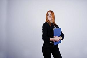 retrato de una mujer de negocios pelirroja con blusa a rayas y una chaqueta con una carpeta azul. foto