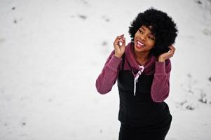 Curly hair african american woman posed at winter day. Afro model girl against snow. photo