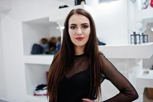 Brunette gorgeous girl in the clothing store boutique at black dress. photo