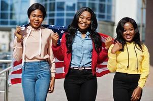 tres jóvenes universitarias amigas afroamericanas con bandera de estados unidos. foto