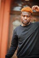 African red haired man wear black outfit posing outdoor. photo