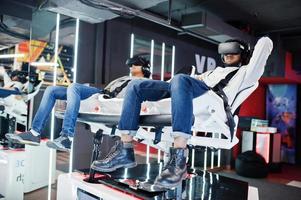 Two young indian people having fun with a new technology of a vr headset at virtual reality simulator. photo