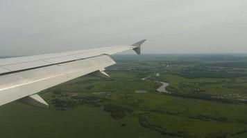 el avión desciende para aterrizar en el aeropuerto de kazán, vista desde el ojo de buey de la cabina. video