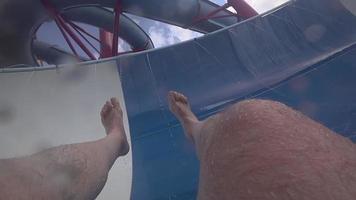 Middle aged man sliding down the fun water slide at water park video