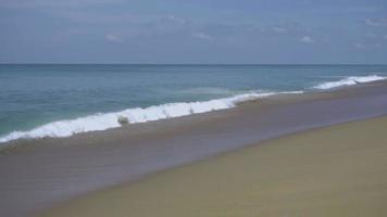 türkisfarbene wellen rollten auf den strandsand, mai khao beach, phuket, zeitlupe video