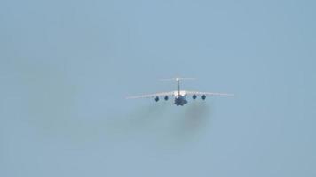 transporte pesado ascenso de aviones después del despegue, vista trasera de tiro largo. Avión estratégico turboventilador de cuatro motores de ala fija multipropósito video