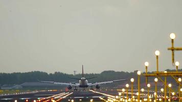 Verkehrsflugzeug landet bei Seitenwind auf der Landebahn. Blick vom Rand der Landebahn hinter als Masten video