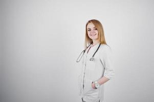 Blonde doctor nurse with stethoscope isolated on white background. photo