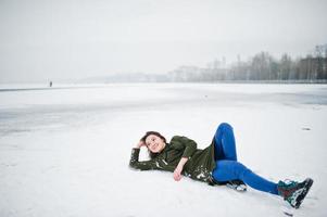 Funny girl wear on long green sweatshirt and jeans, at frozen lake in winter day. photo