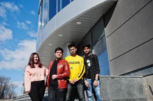 grupo de amigos asiáticos parados en las escaleras al aire libre contra un edificio moderno. foto