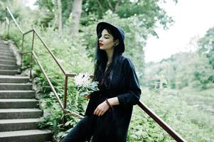 Sensual girl all in black, red lips and hat. Goth dramatic woman. photo