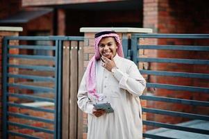 Middle Eastern arab man posed on street against modern building with tablet at hands. photo