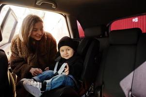 Young mother and child in car. Baby seat on chair. Safety driving concept. photo