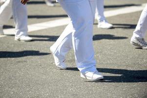 Marcha militar en una calle. piernas y zapatos en linea foto