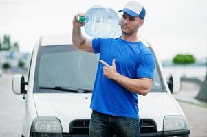 repartidor en camioneta de carga delantera entregando botellas de agua mostrando el dedo. foto