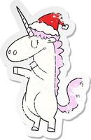 distressed sticker cartoon of a unicorn wearing santa hat vector