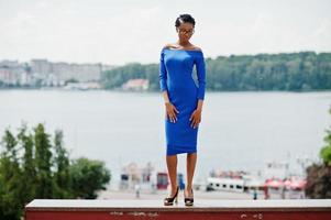 African american curly girl posed at street of city wear on blue dress. photo