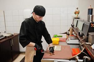 Professional chef wear in black making sushi and rolls in a restaurant kitchen of japanese traditional food. photo