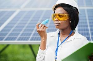 African american technician check the maintenance of the solar panels. Black woman engineer at solar station. photo