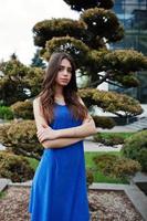 Teenage girl in blue dress posed outdoor at sunny day. photo