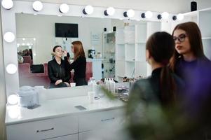 maquilladora trabaja en su salón de estudio de rostro de belleza. mujer solicitando por maestro de maquillaje profesional. concepto de club de belleza. foto