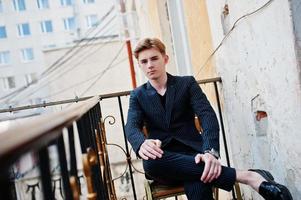 Young stylish macho boy in black jacket posed outdoor of street. Amazing model man. photo