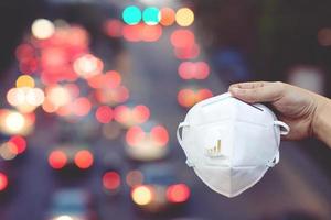 close up hand holding submit wearing facial hygienic mask nose outdoor. Ecology, air pollution car, Environmental and virus protection concept flu health against toxic dust the city of a health effect photo