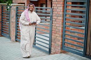 Middle Eastern arab man posed on street against modern building with tablet at hands. photo