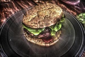 Kirlian glowing of a grilled burger with tomatoes and salad on a white plate. photo