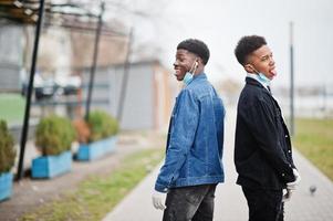 Two african teenagers friends at park wearing medical masks protect from infections and diseases coronavirus virus quarantine. photo