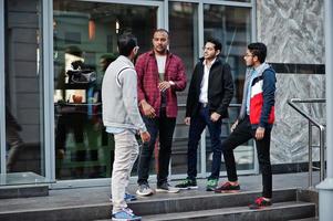 Group of four indian teen male students. Classmates spend time together. photo